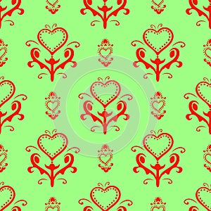 Seamless background with hearts. On a green background. The heart is woven into a bright red ornament. Christmas repeating texture