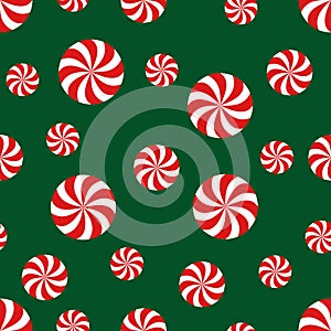 Seamless Christmas pattern with candy on green background.