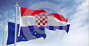 Seamless loop in slow motion of Croatia and the EU flag waving on a clear day