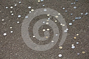 Seamless pattern of coins lying on asphalt