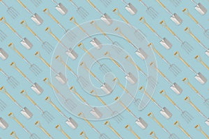 Seamless pattern with gardening tool and garden equipment, spade and fork with wooden handle, isolated top view on light blue