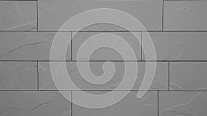 A seamless pattern of grey rectangular stone tiles with subtle linear texture and grout lines