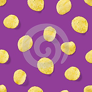 Seamless pattern made from Potato chips on purpule background flat lay. potato snack chips isolated Fast food banner.