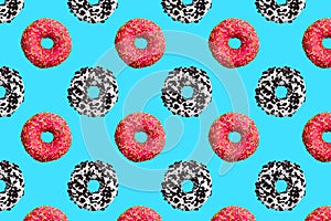Pattern of pink, white and chocolate donuts on blue background top view, tasty doughnuts backdrop, colorful sweet dessert