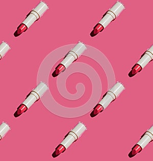 Seamless pattern of red tinted balm lipstick flat lay on pink paper.