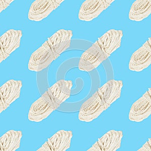 Seamless pattern of a skein of white rope on blue background
