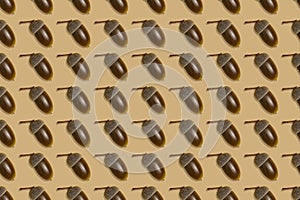 Seamless pattern of ripe acorns on a brown background