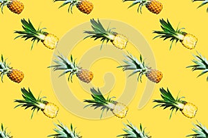Seamless pattern of ripe pineapples isolated on yellow background. Top view