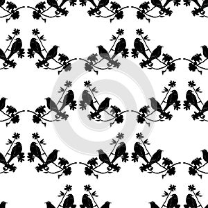 Seamless pattern with silhouette of birds sitting on twigs. Vector background with branches of tree.