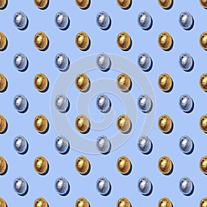 Seamless Pattern of sparkly chocolate foil eggs on blue background.
