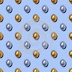 Seamless Pattern of sparkly chocolate foil eggs on blue background.