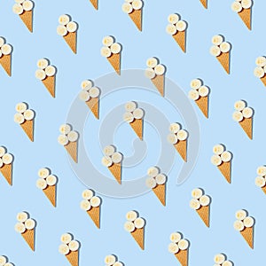 Seamless pattern of stylish mockup with banana slices in an ice cream waffle cone on a pastel blue background. Creative