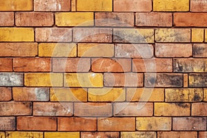 Seamless pattern texture background with an aged yellow and red brick wall.