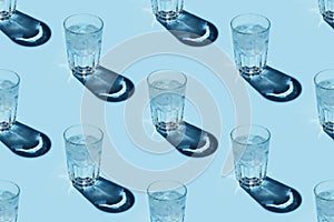 Seamless pattern with transparent glasses of water with ice on blue background