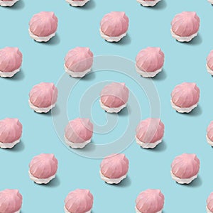 Seamless pattern of two-tone white and pink marshmallows on a blue background