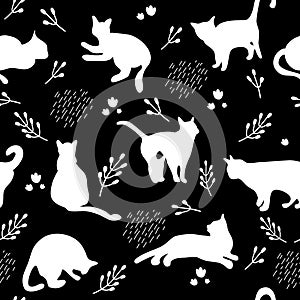 Seamless pattern with white cats silhouettes on black background. Cute kittens.Feline in different poses.Animals sit,lay,relax.