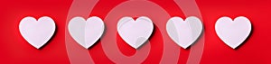 Seamless pattern of white hearts on red background. Top view. Valentine`s Day. Love, date, romantic concept. Banner