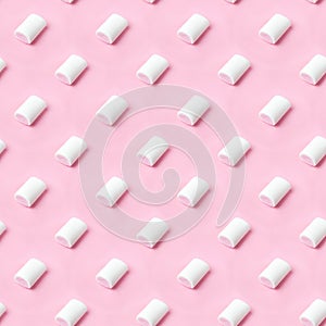 Seamless pattern white-pink marshmallows placing on pink flatlay. Marshmallow pastel colors on pink background