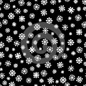 Seamless pattern of white snowflakes on a black background. Simple pattern for backdrops, wrapping paper and seasonal