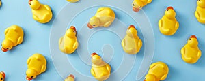 A seamless pattern of yellow rubber ducks scattered across a light blue background, creating a fun