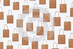 Seamless photo pattern of brown craft packaging bags for shopping on a white background.