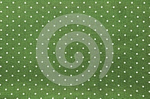 Seamless polka dots pattern on green fabric