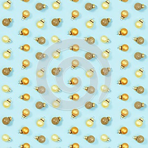 Seamless regular creative pattern with bright shiny little Christmas balls on blue paper.