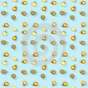 Seamless regular creative pattern with bright shiny little Christmas balls on blue paper.