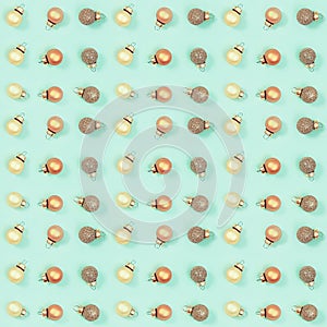 Seamless regular creative pattern with bright shiny little Christmas balls on mint colored paper