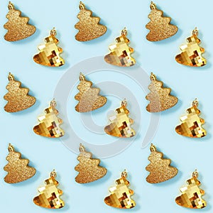 Seamless regular creative pattern with metallic golden Christmas tree toys on blue color.