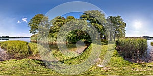 Seamless spherical hdri panorama 360 degrees angle view on grass coast of huge river or lake in sunny summer day and windy weather