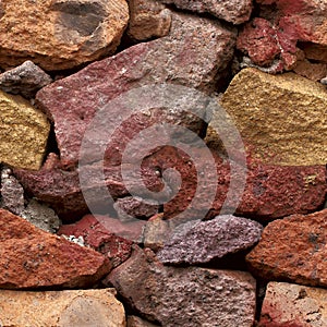 Seamless texture. Background of red and yellow stones of different shapes.