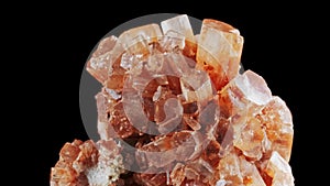 Seamlessly rotating a blood orange mineral Aragonite in front of black background