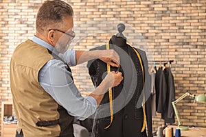 Seamster tailoring jacket on mannequin in atelier