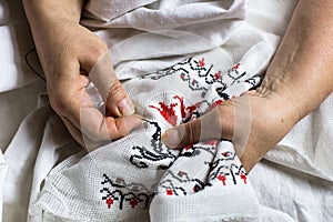 Seamstres`s hands. Female hands with a needle, thread and thimble. Woman embroiders clothes