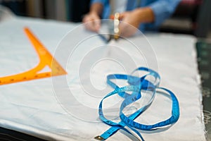 Seamstress cuts fabric with scissors in workshop
