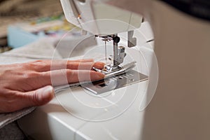 Seamstress hand guides seam on modern sewing machine