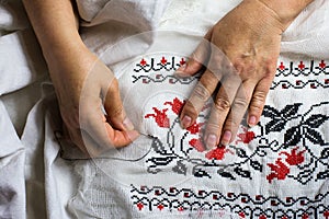 Seamstress hands. Female hands with a needle, thread and thimble. Woman embroiders clothes.