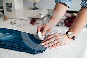 Seamstress marking hem on a pair of jeans