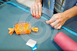 Seamstress measures fabric material, top view