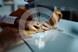 Seamstress sews cloth on sewing machine, workshop