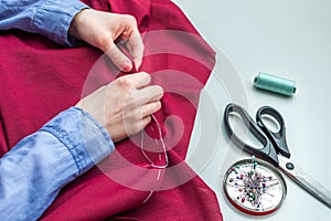 Seamstress sews clothes by hand. Accessories for sewing. Hands of women