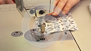 seamstress sews a piece of fabric on a sewing machine