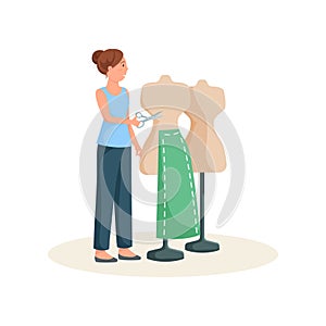 Seamstress standing near mannequin in green skirt pattern with scissors in hands