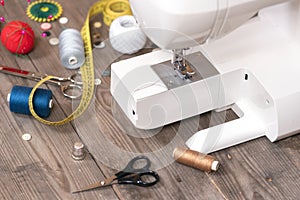 Seamstress or tailor background with sewing tools, colorful threads, sewing machine and accesories .