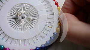 A seamstress woman pulls out a pin
