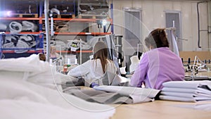 Seamstresses at a garment factory. Workflow at a textile factory. Modern sewing workshop. Inside a textile factory