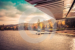 Seaplane docked at the shore awaiting leaf-peepers and adventure seekers, retro split tone