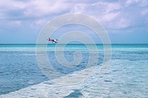 Seaplane landing at beautiful Maldives island beach