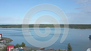 A seaplane sliding on Yellowknife Bay, viewed from the top of the Pilot`s monument in Old Tow